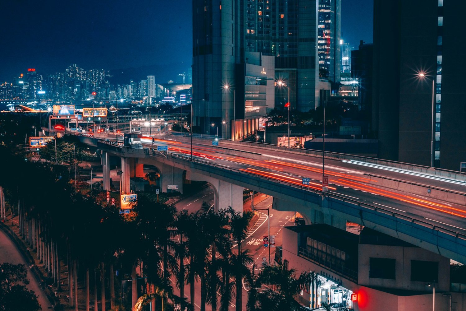 Carretera elevada iluminada y edificios altos de noche