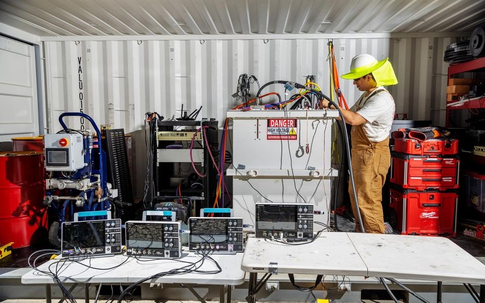 An engineer working beside high-voltage test equipment