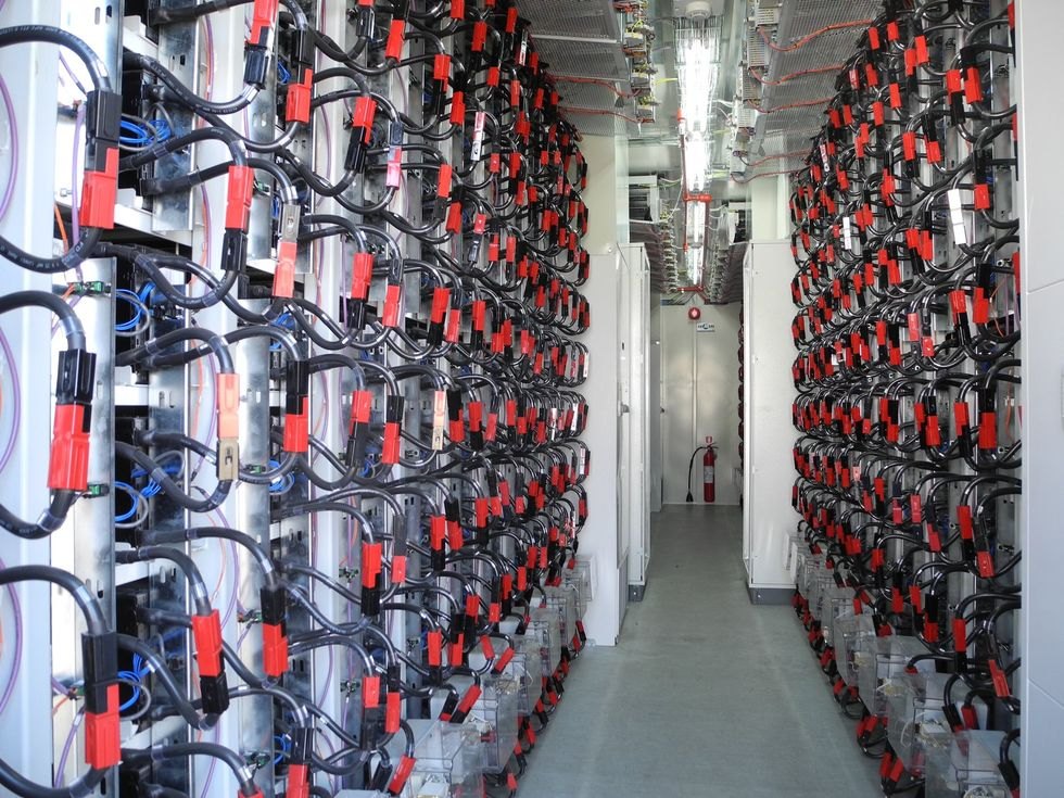Rows of battery racks with connected electrical cables